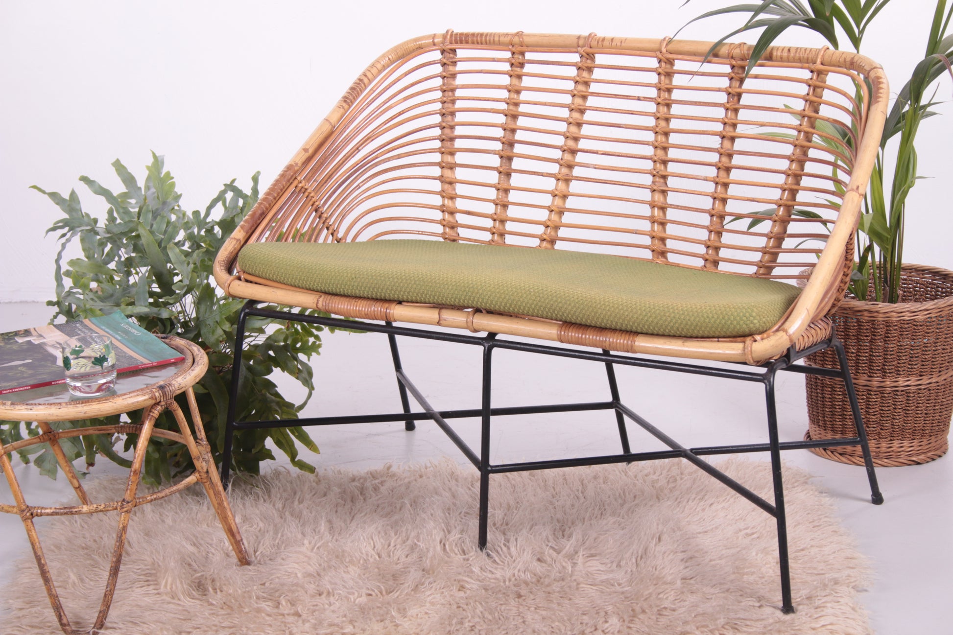 Vintage design rotan lounge bank met lime groen kussen sfeerfoto
