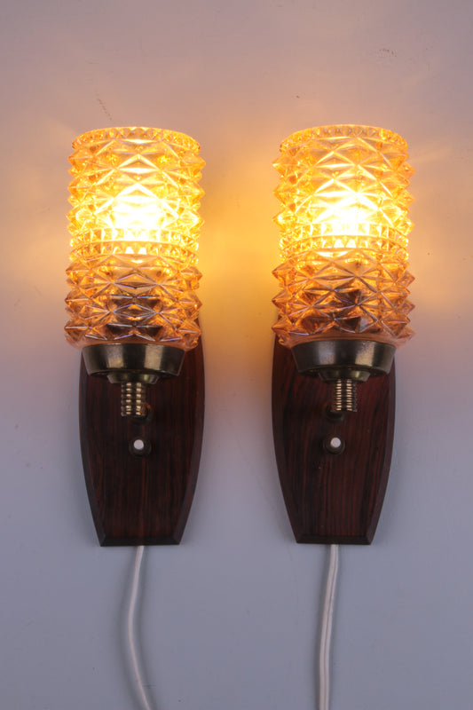 Set Deense wandlampjes gemaakt van teak en gekleurd glas voorkant licht aan
